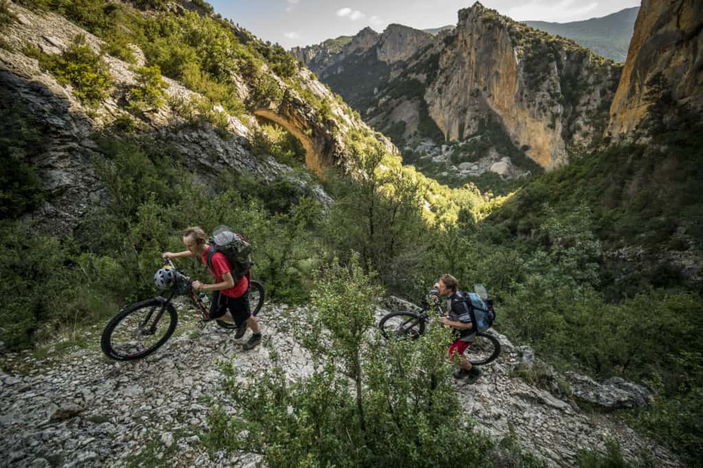 Pushing bikes up the steep rocky trail